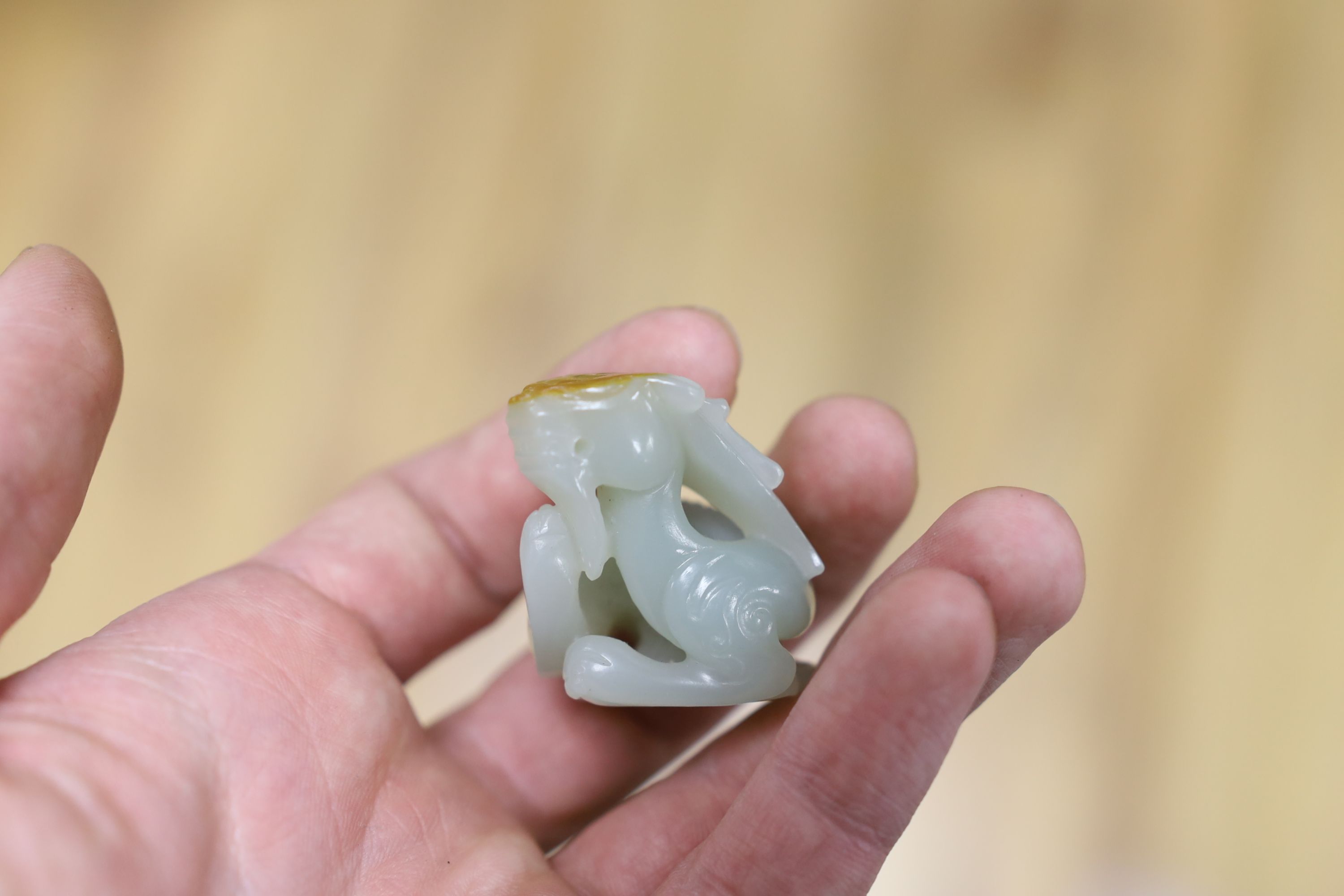 A Chinese pale celadon and russet skin jade figure of a dragon, 4cm high